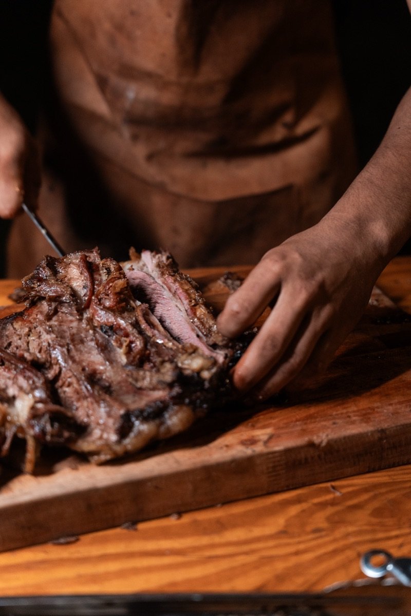 Corte de carne asada sobre tabla de madera
