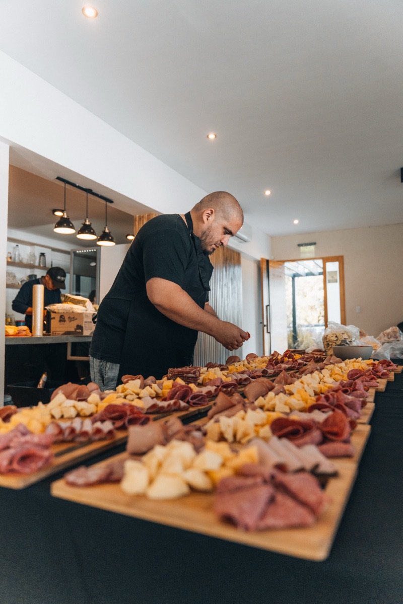Chef preparando una mesa de fiambres y quesos